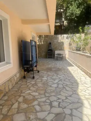 a patio with a stone floor and a fireplace at Villa Grand in Bar