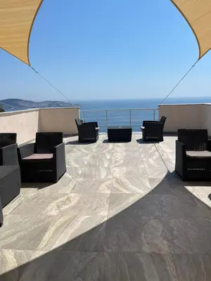 a patio with chairs and a view of the ocean at Villa Grand in Bar