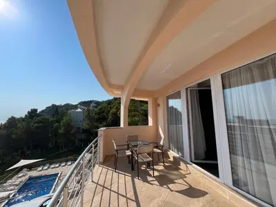 a balcony with a table and chairs and a pool at Villa Grand in Bar