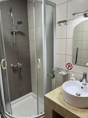 a bathroom with a shower and a sink at Villa Grand in Bar