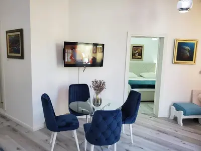 a dining room with a table and blue chairs at MM Apartment in Budva