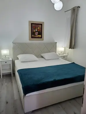 a bedroom with a large bed with a blue blanket at MM Apartment in Budva