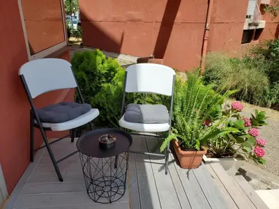 two chairs and a table on a patio with plants at MM Apartment in Budva