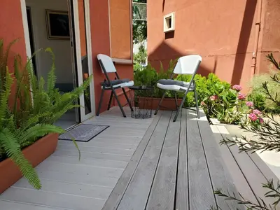 two chairs and a table on a porch with plants at MM Apartment in Budva