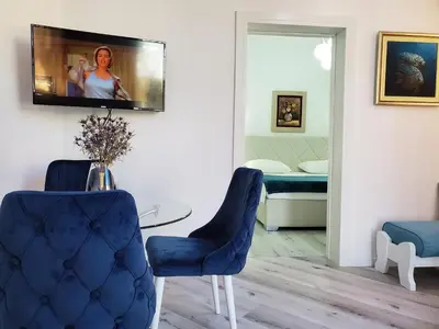 a living room with two blue chairs and a table at MM Apartment in Budva