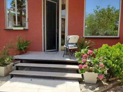 a porch with a chair and flowers in front of a house at MM Apartment in Budva