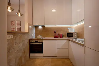 a kitchen with white cabinets and a microwave at 2montenegro HARMONIA APARTMENTS Becici in Becici