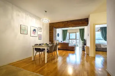 a dining room and living room with a table and chairs at 2montenegro HARMONIA APARTMENTS Becici in Becici