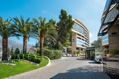 a street with palm trees next to a building at 2montenegro HARMONIA APARTMENTS Becici in Becici