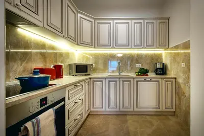 a kitchen with white cabinets and a sink and a microwave at 2montenegro HARMONIA APARTMENTS Becici in Becici
