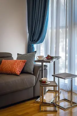 a living room with a couch and two tables at 2montenegro HARMONIA APARTMENTS Becici in Becici