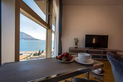 a room with a table with a bowl of fruit on it at 2montenegro HARMONIA APARTMENTS Becici in Becici