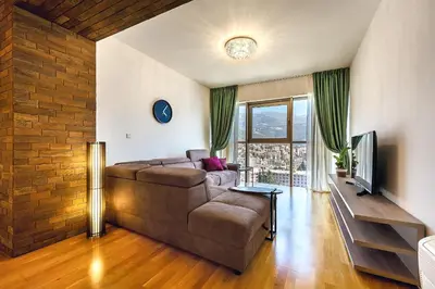 a living room with a couch and a television at 2montenegro HARMONIA APARTMENTS Becici in Becici