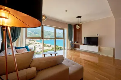 a living room with a couch and a large window at 2montenegro HARMONIA APARTMENTS Becici in Becici