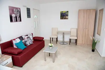 a living room with a red couch and a table at Apartments Nino Skadar lake in Virpazar