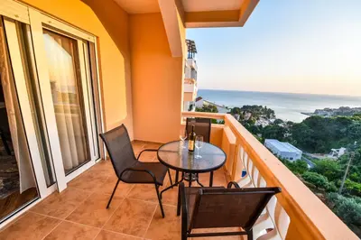 a balcony with a table and chairs and the ocean at Dragovoja Lux Apartments & Rooms in Ulcinj