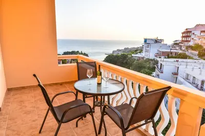 a balcony with a table and chairs and the ocean at Dragovoja Lux Apartments & Rooms in Ulcinj