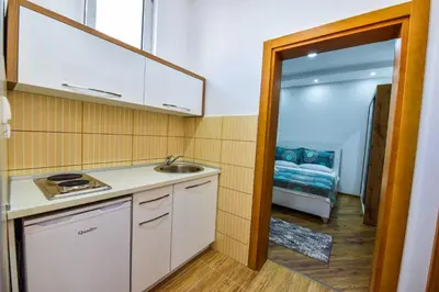a kitchen with a sink and a room with a bed at Dragovoja Lux Apartments & Rooms in Ulcinj