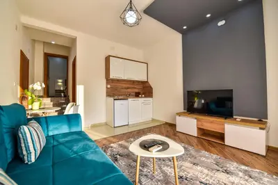 a living room with a blue couch and a tv at Dragovoja Lux Apartments & Rooms in Ulcinj