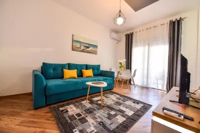 a living room with a blue couch and a table at Dragovoja Lux Apartments & Rooms in Ulcinj