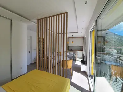 a bedroom with a yellow bed and a balcony at Viola lux apartments in Kotor