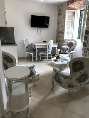 a living room with chairs and a table and a tv at New renovated Old Town Martiva Apartment in Kotor