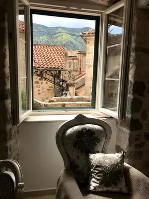 a chair sitting in front of a window with a view at New renovated Old Town Martiva Apartment in Kotor