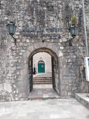 an entrance to a stone wall with a green door at New renovated Old Town Martiva Apartment in Kotor