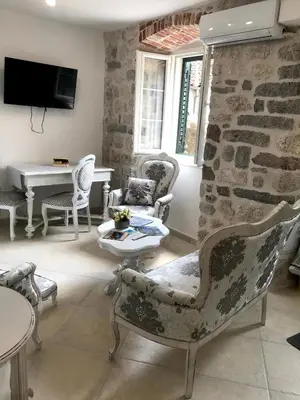 a living room with chairs and a stone wall at New renovated Old Town Martiva Apartment in Kotor