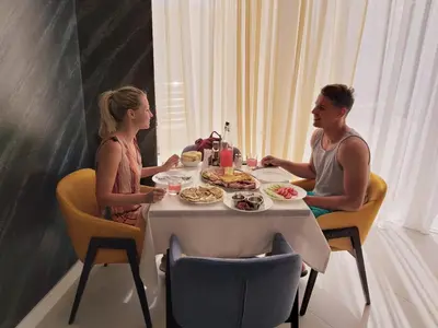 a man and woman sitting at a table eating food at Hotel Pierina in Budva