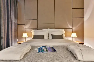 a bedroom with a bed with a book on it at Avanti Hotel & Spa in Budva