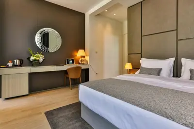 a bedroom with a bed and a desk and a mirror at Avanti Hotel & Spa in Budva