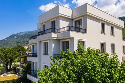 a white building with trees in front of it at Avanti Hotel & Spa in Budva