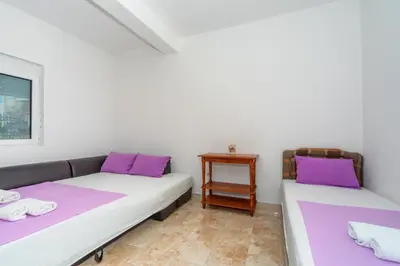 two beds in a room with purple pillows at Apartments Sara in Bar