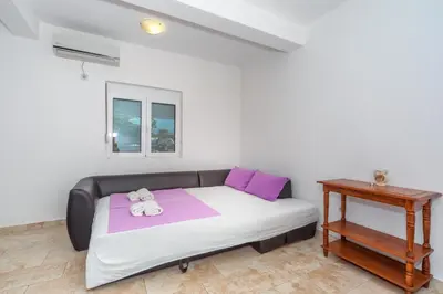 a bedroom with a bed with pink and purple pillows at Apartments Sara in Bar