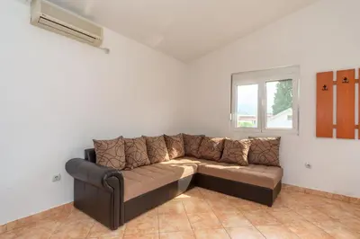 a brown couch in a room with a window at Apartments Sara in Bar