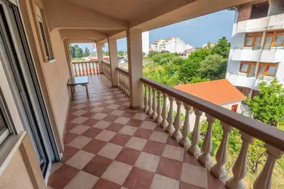 a balcony of a house with a checkered floor at Apartments Sara in Bar
