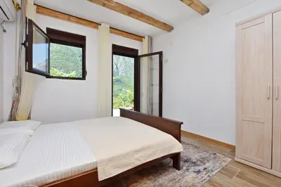 a bedroom with a bed and a window at Rooms Sveti Toma in Virpazar