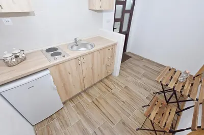 a kitchen with a sink and a counter and chairs at Rooms Sveti Toma in Virpazar