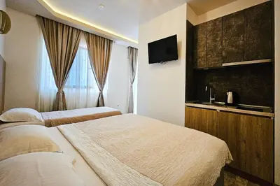 a hotel room with two beds and a television at Basileus Apartments Budva in Budva