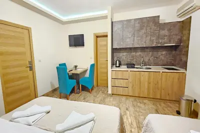 a hotel room with two beds and a kitchen at Basileus Apartments Budva in Budva