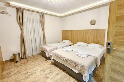 a hotel room with two beds and a window at Basileus Apartments Budva in Budva