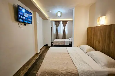 a hotel room with two beds and a flat screen tv at Basileus Apartments Budva in Budva
