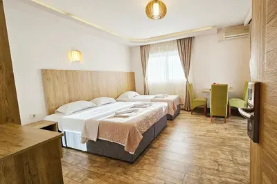 a hotel room with two beds and a television at Basileus Apartments Budva in Budva
