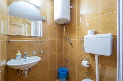 a bathroom with a sink and a mirror and a toilet at Bel Mare Apartments in Budva