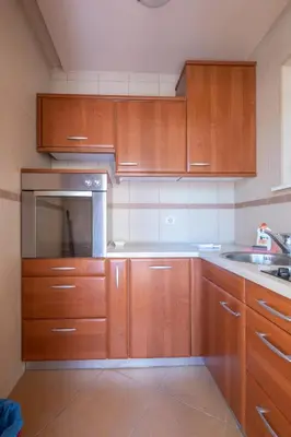 a kitchen with wooden cabinets and a sink at Bel Mare Apartments in Budva