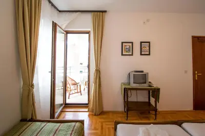a room with a bed and a television on a table at Guesthouse Dapcevic in Budva