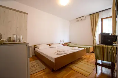 a bedroom with a bed and a tv in it at Guesthouse Dapcevic in Budva