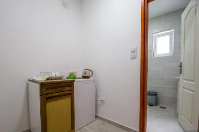 a small kitchen with a refrigerator and a shower at Guesthouse Dapcevic in Budva