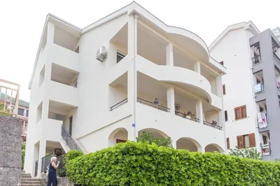 a white building with people on the balconies at Guesthouse Dapcevic in Budva